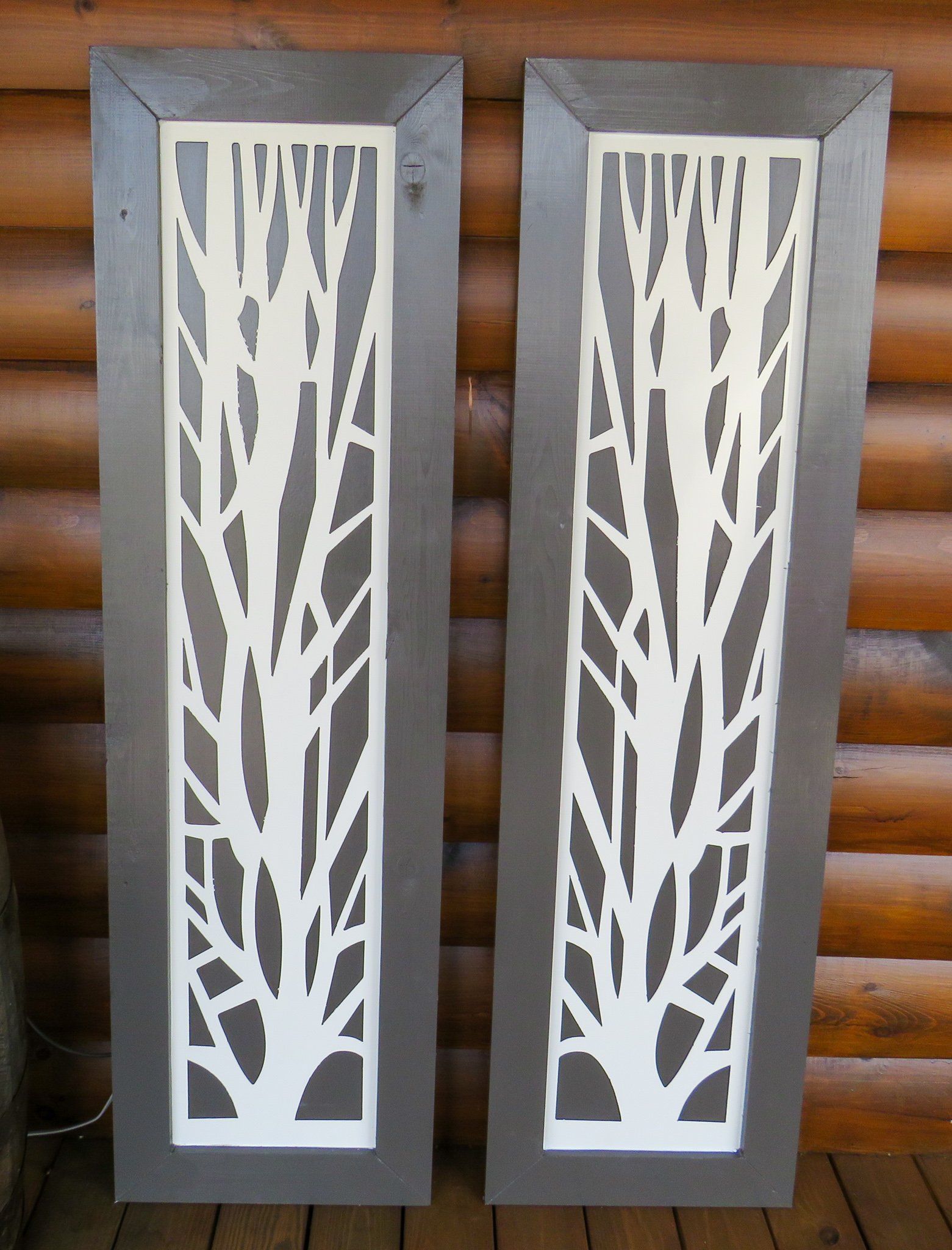 Two pieces of wood with trees cut out of them