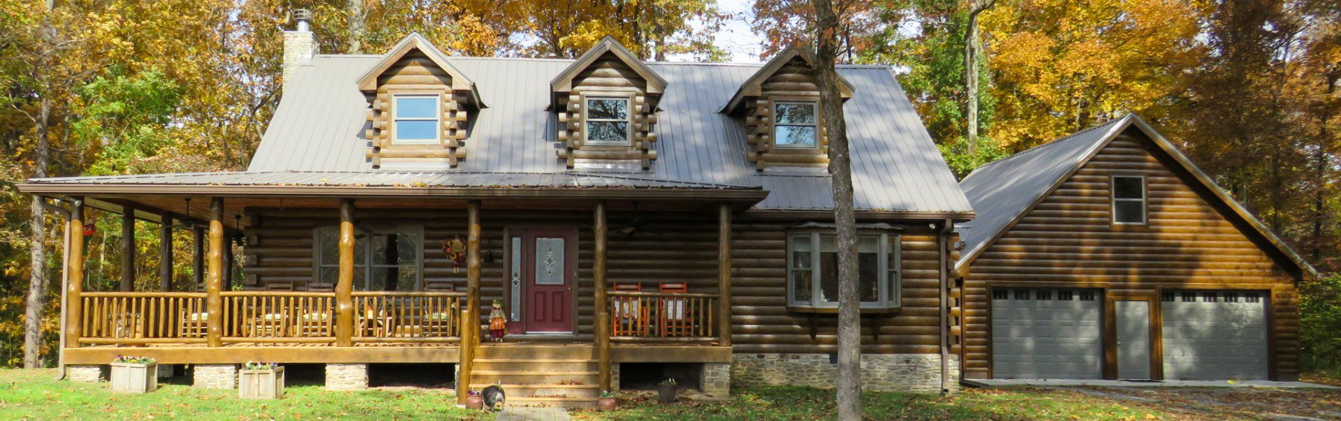A large log cabin with a porch and a garage
