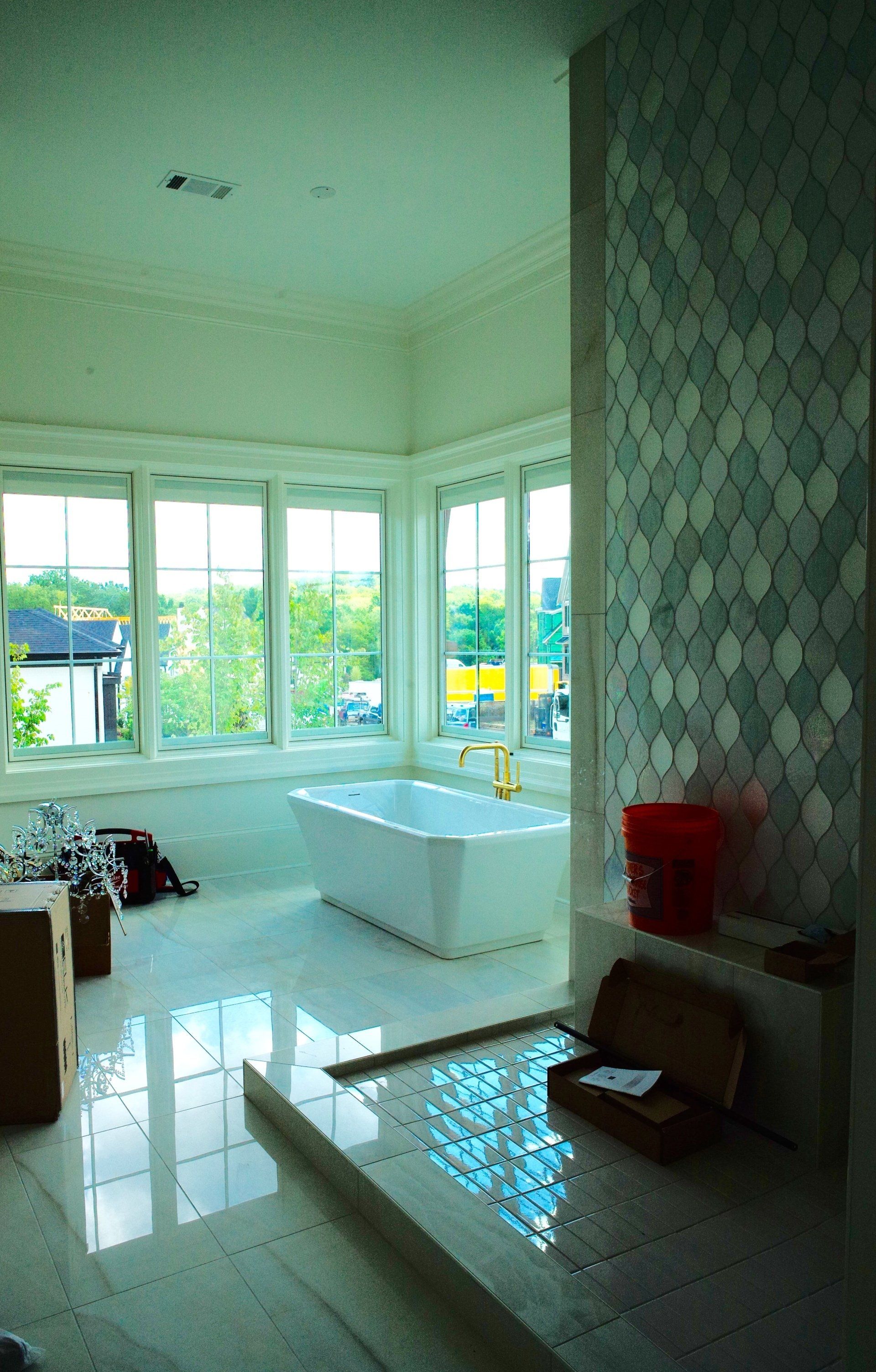 A bathroom with a tub and a lot of windows.