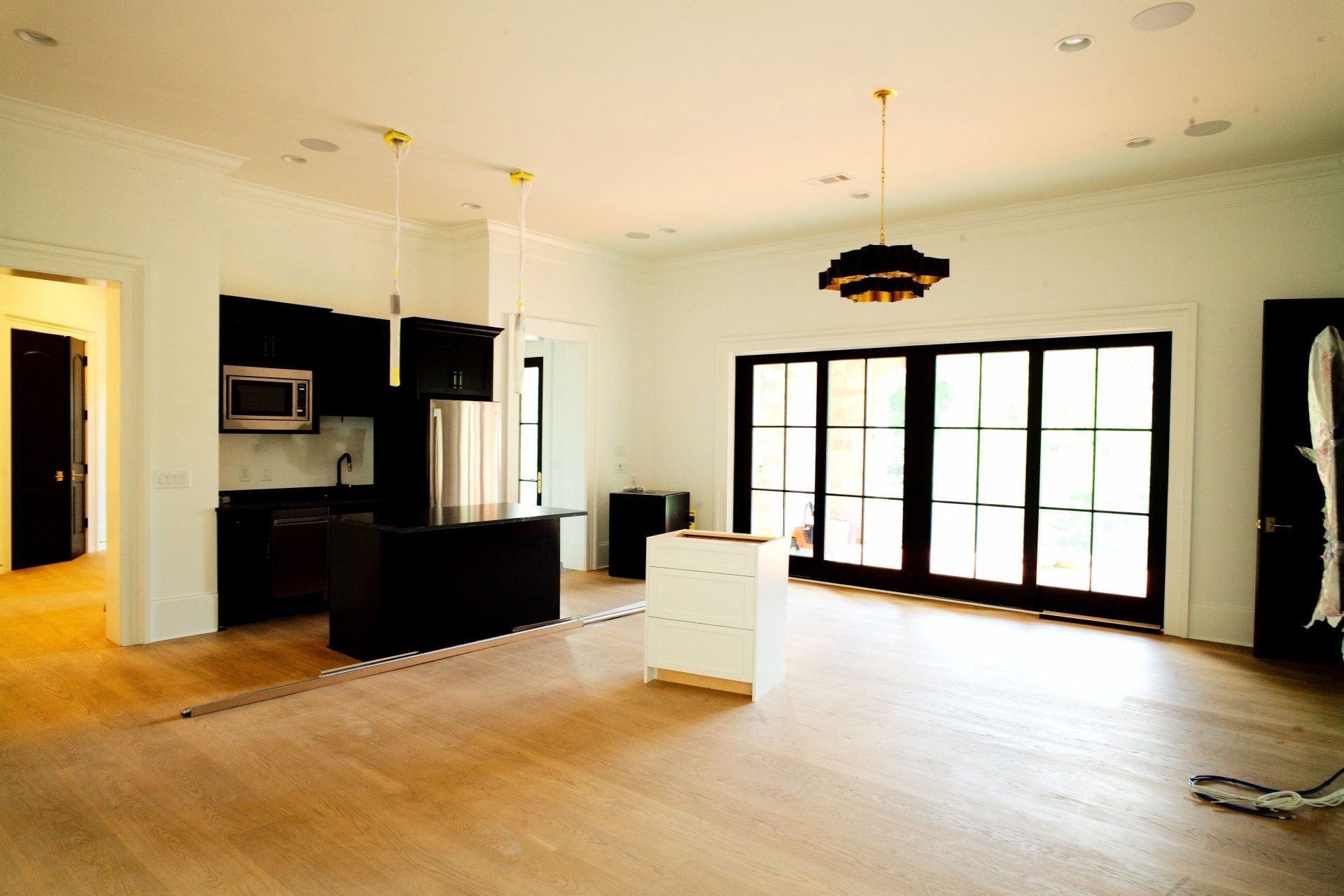 A large empty room with a kitchen and sliding glass doors