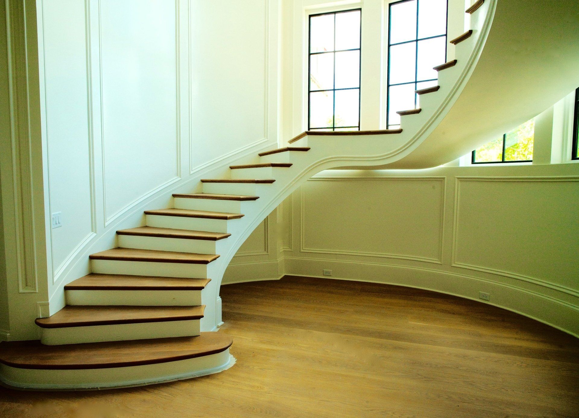 A curved staircase in a room with a window