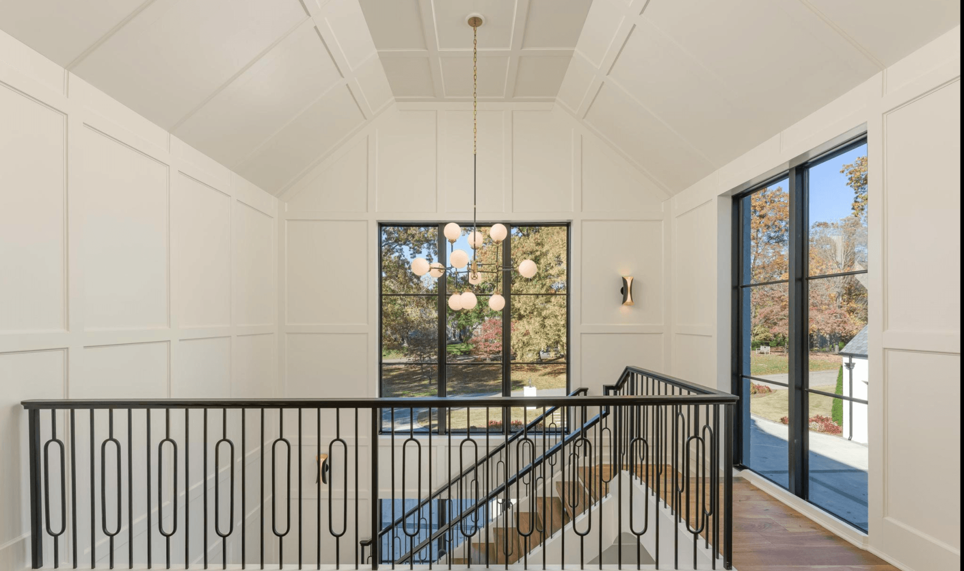 A staircase with a railing and lots of windows in a house.