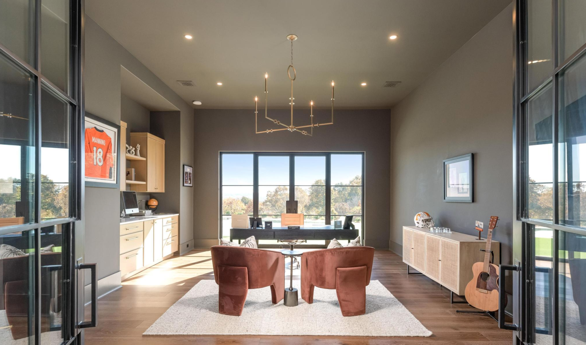 A living room with two chairs and a guitar in it