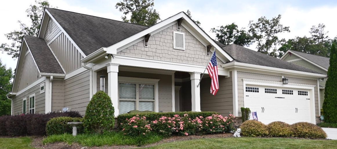 A house with an american flag on the front porch.