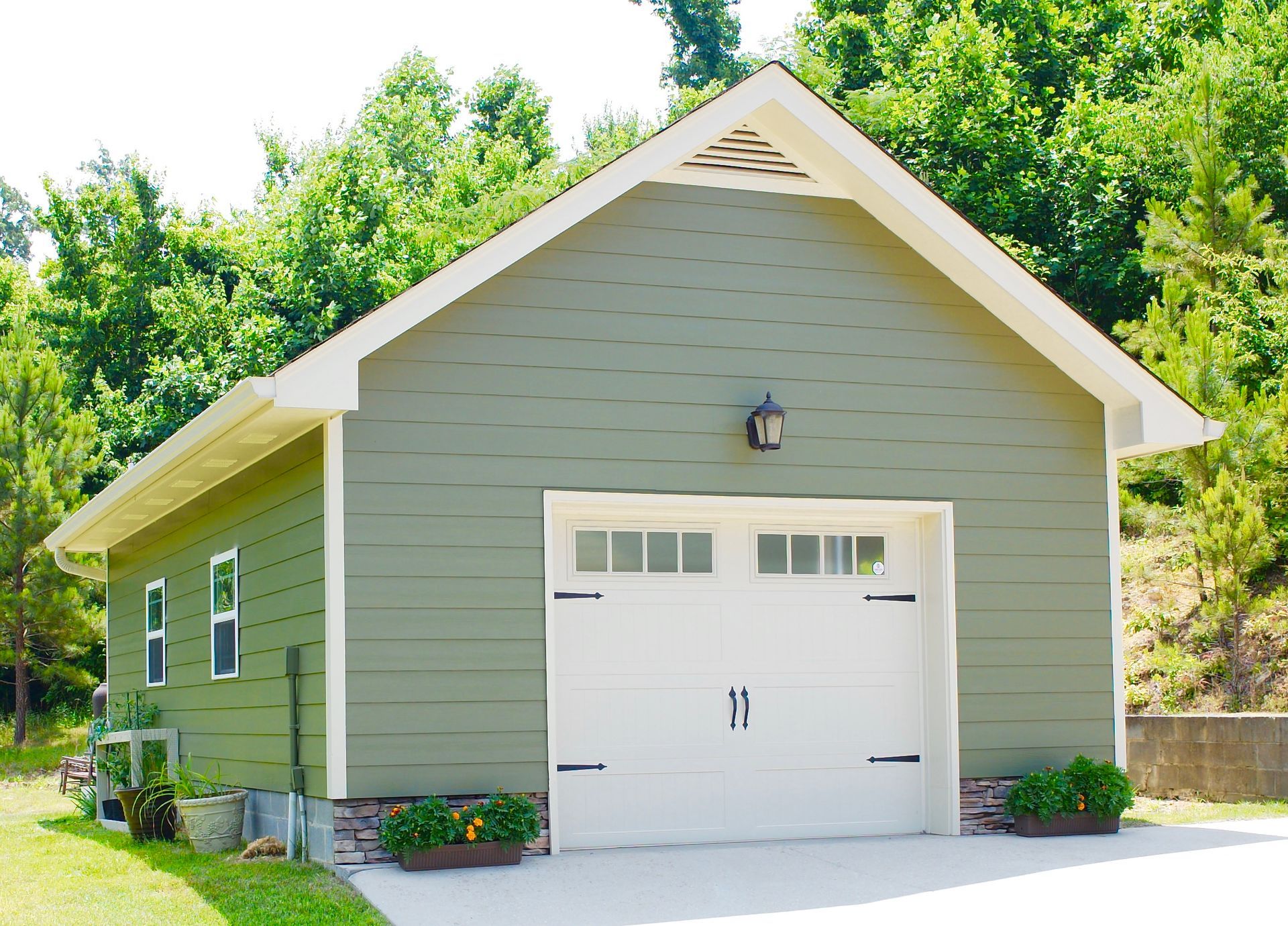 A green garage with a white door has the number 11 on it