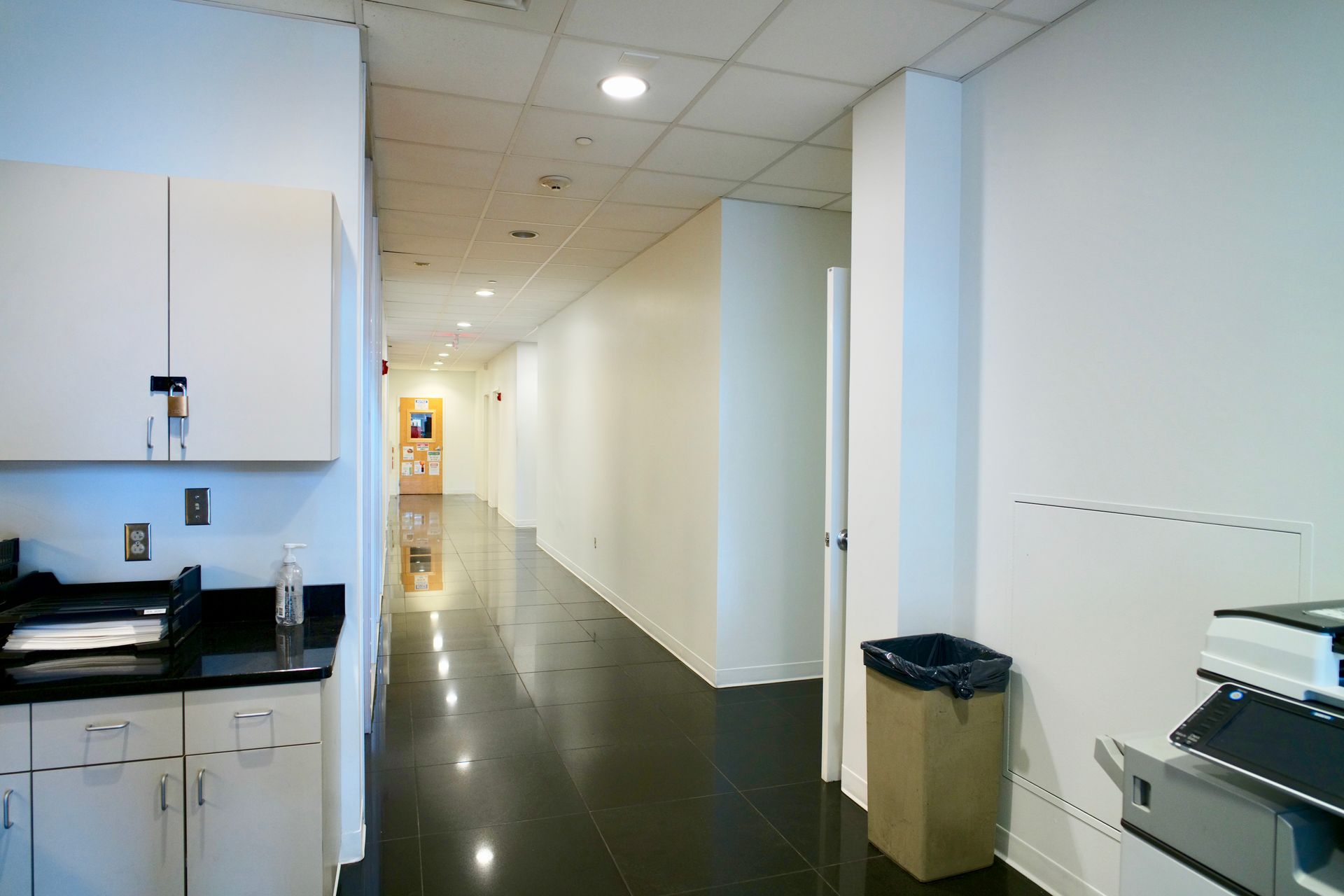 A long hallway with a trash can in the middle