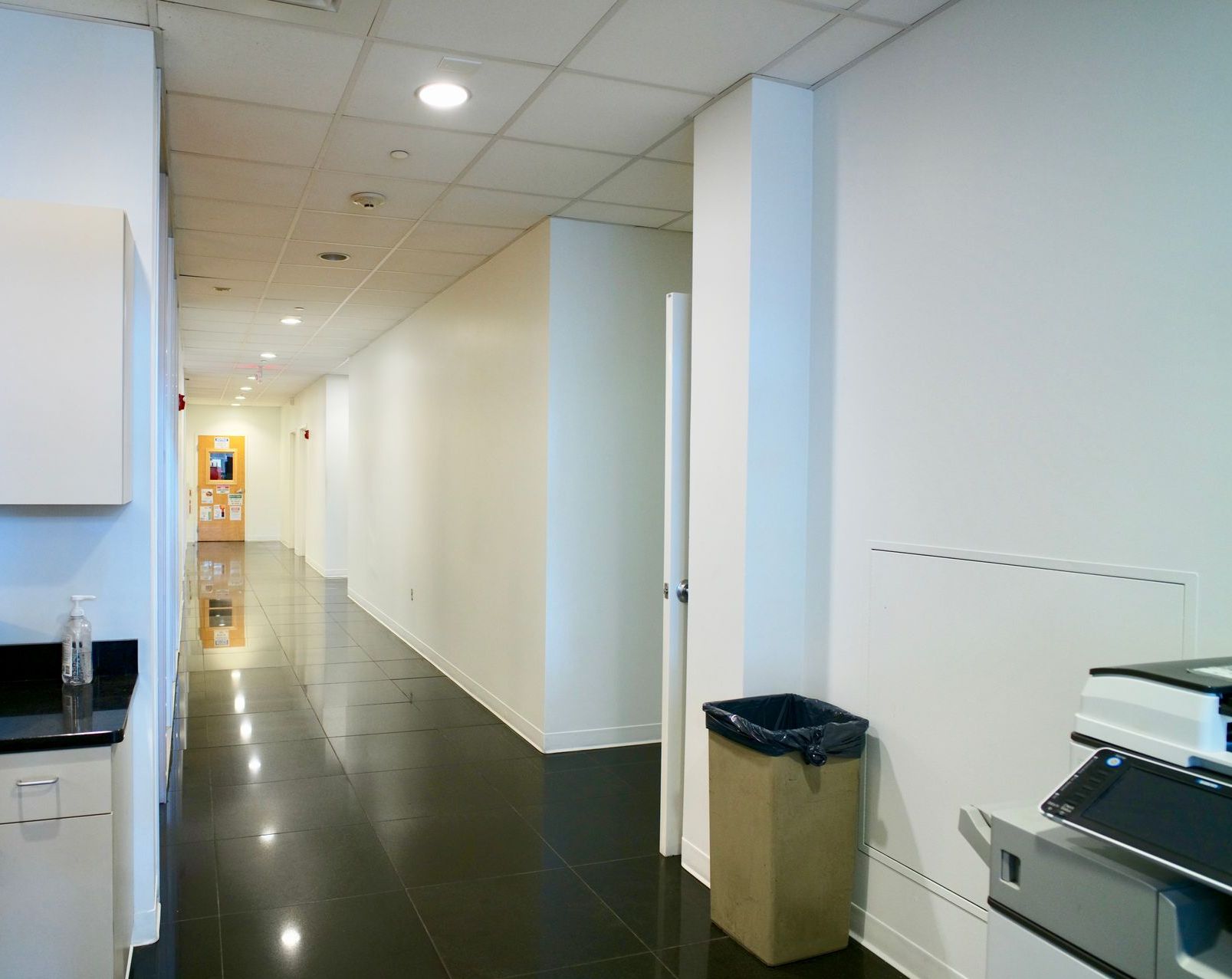 A long hallway with a trash can in the middle