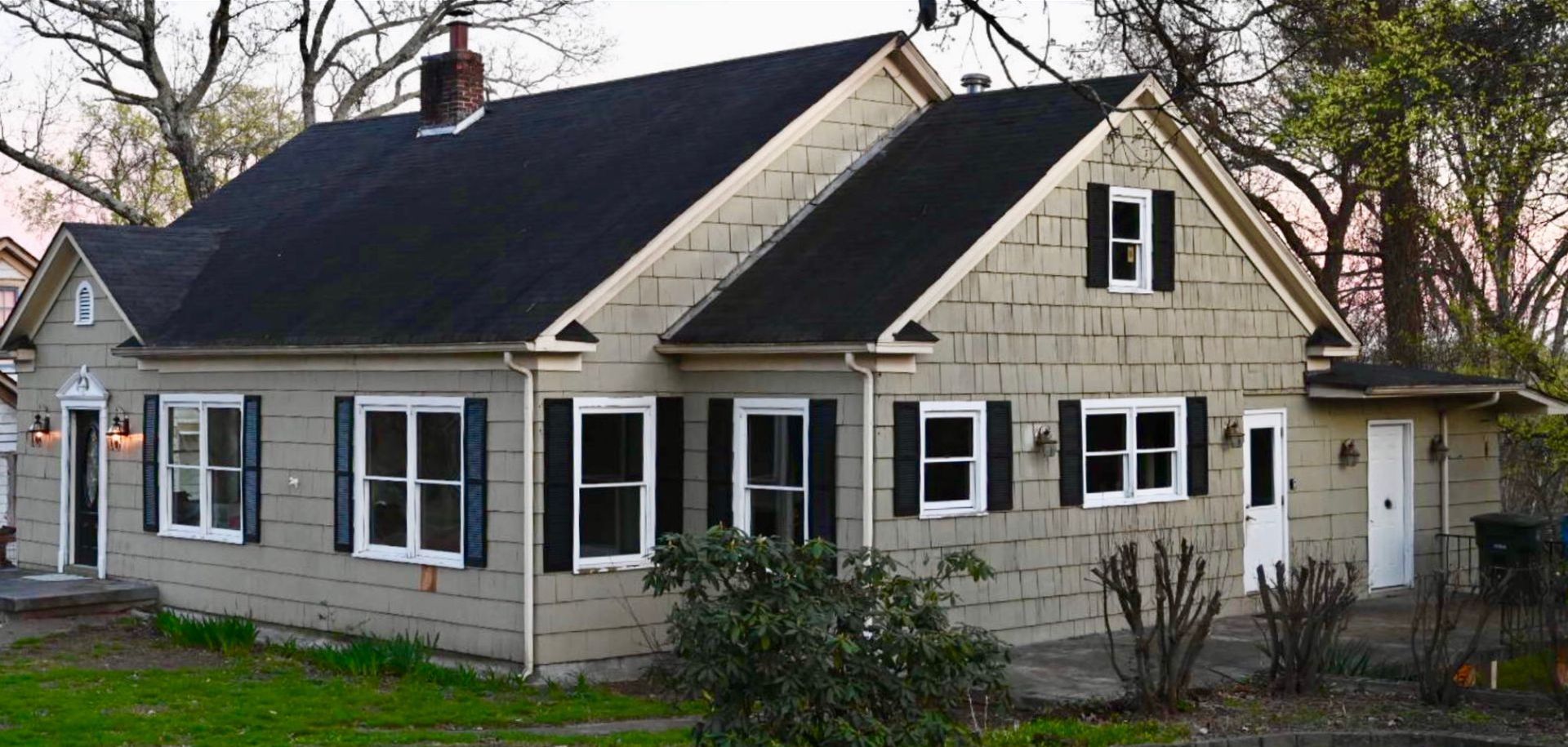 A house with a black roof and white shutters