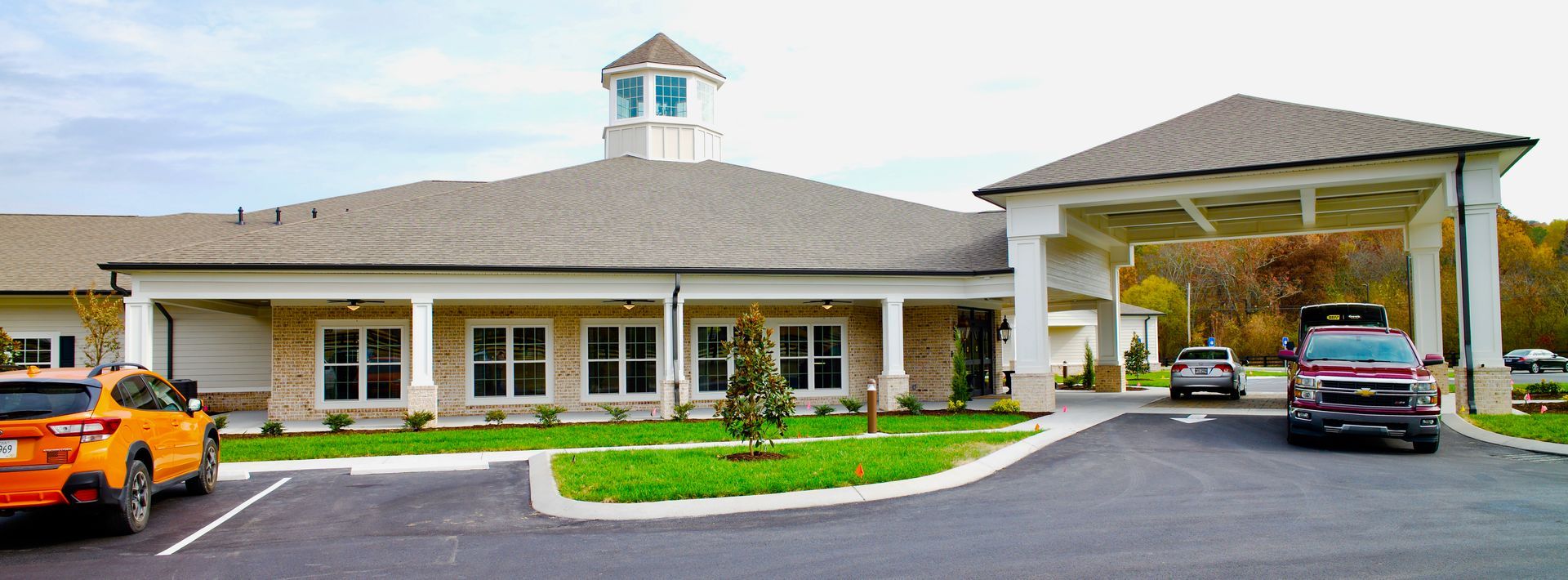 A car is parked in front of a large building.
