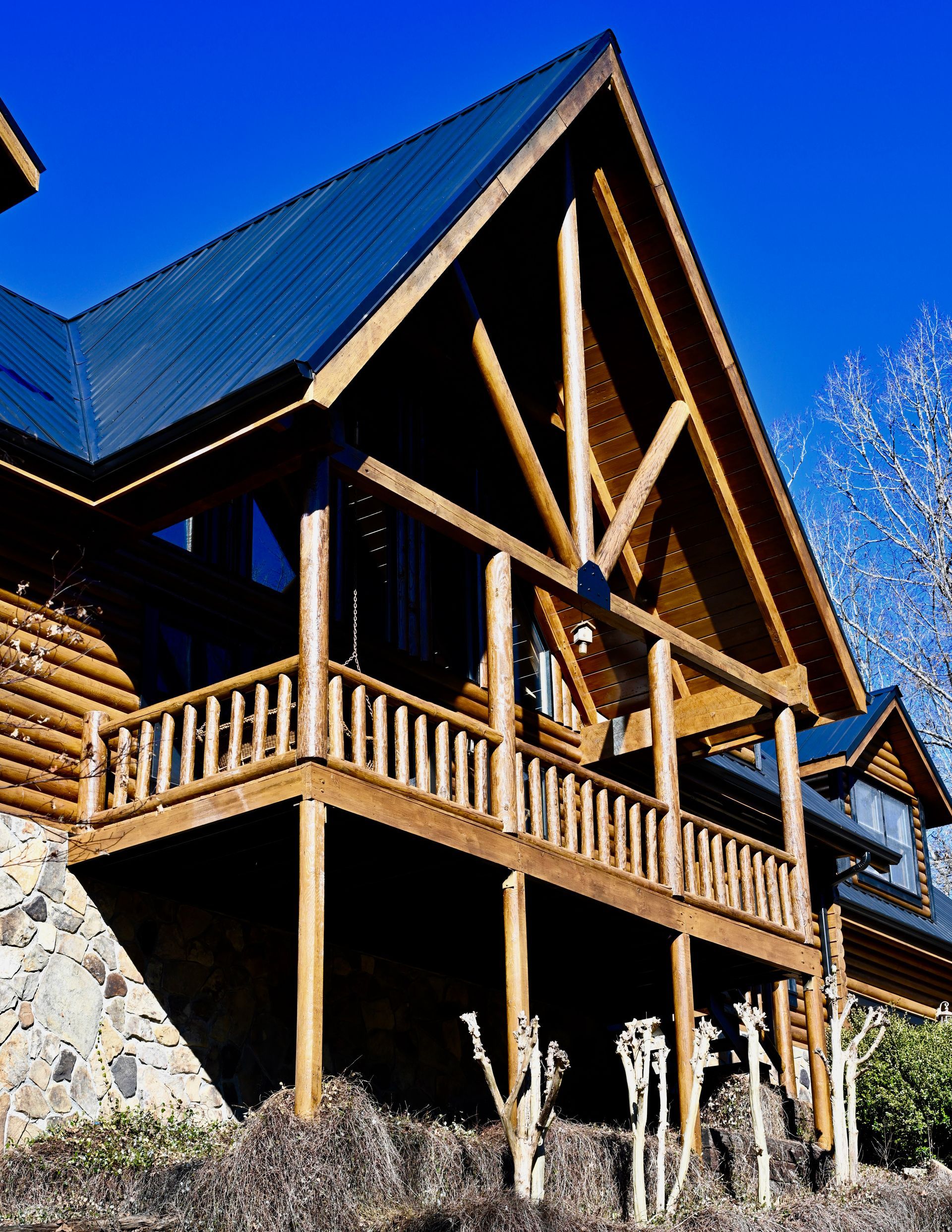 A large log cabin with a blue roof and a balcony