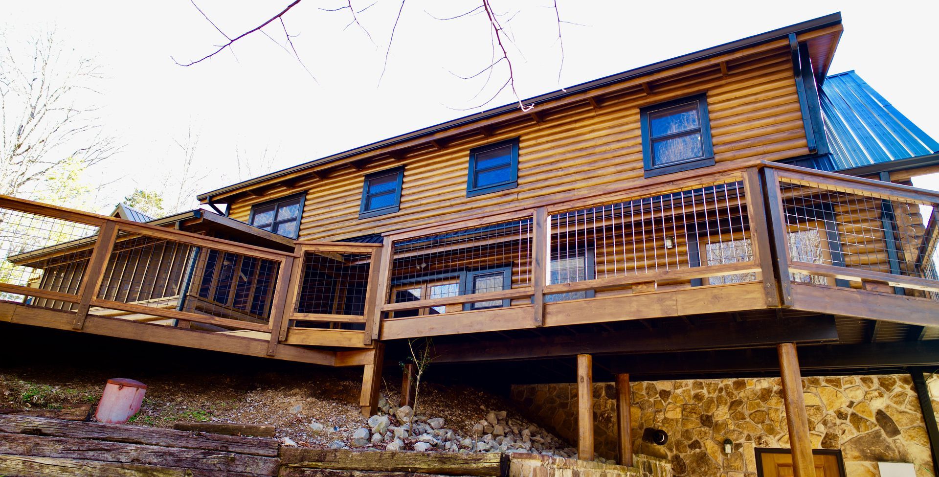 A large log cabin with a large deck on top of it.