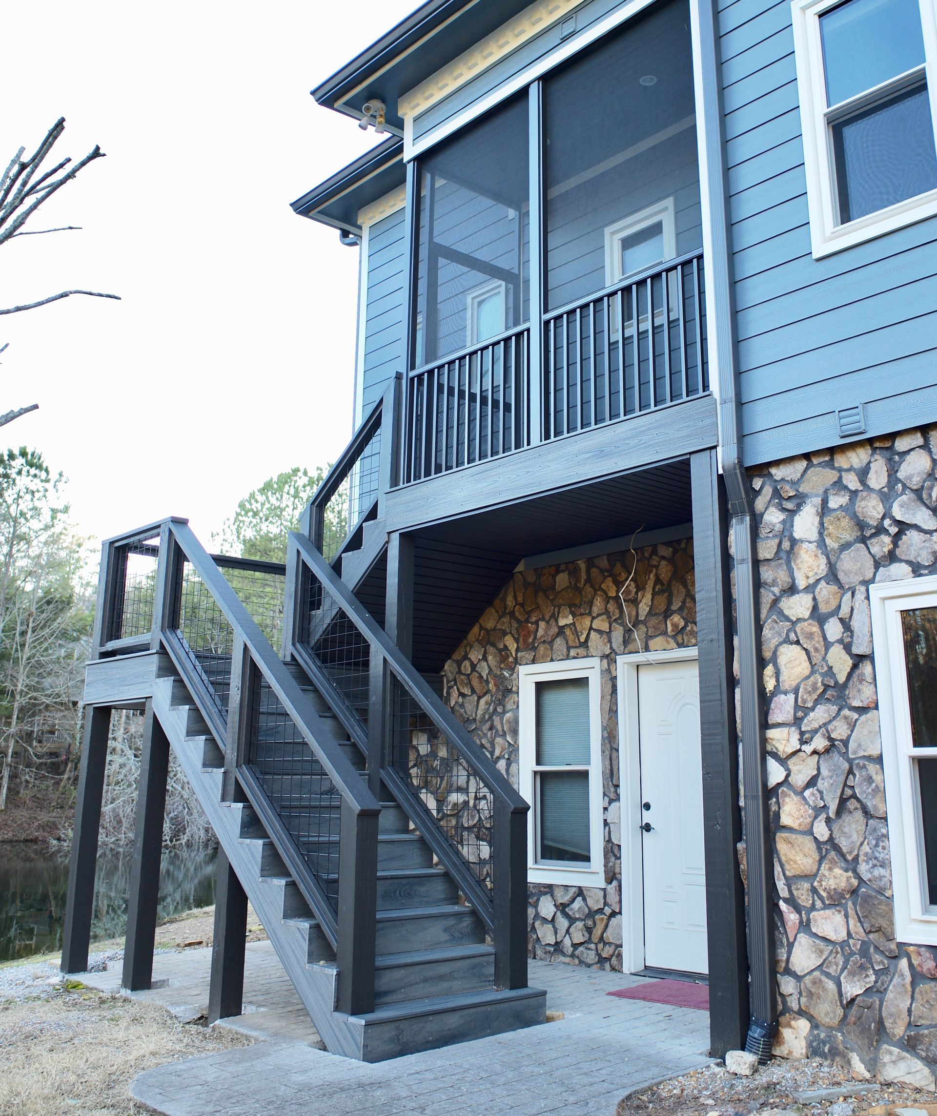 A house with a screened in porch and stairs leading up to it