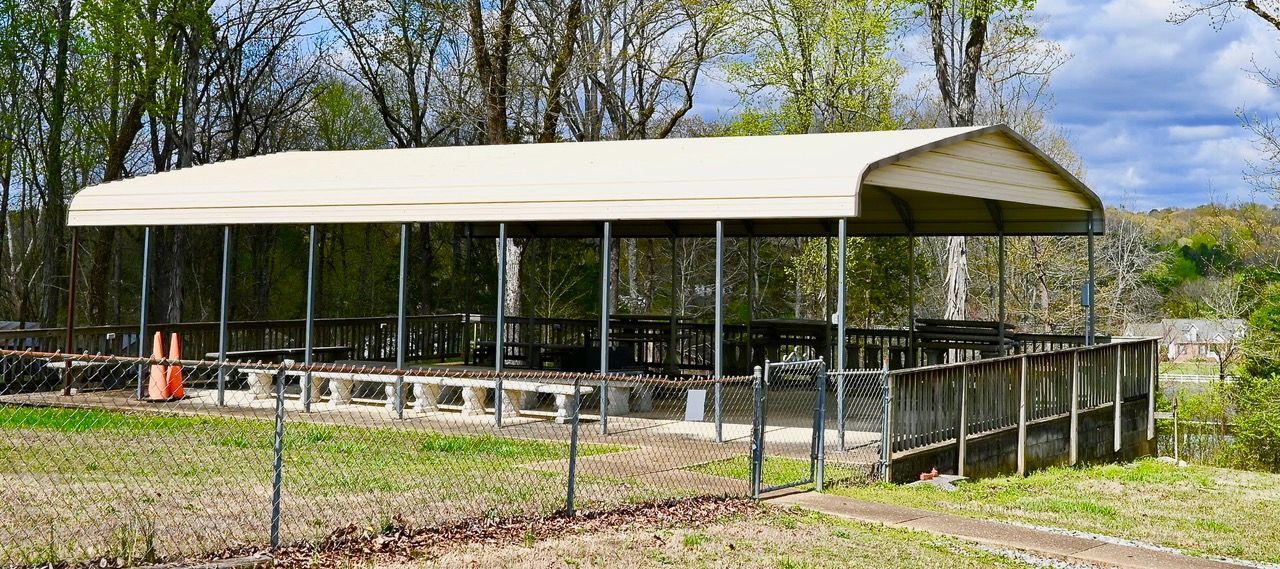 There is a covered area with tables and chairs underneath it.