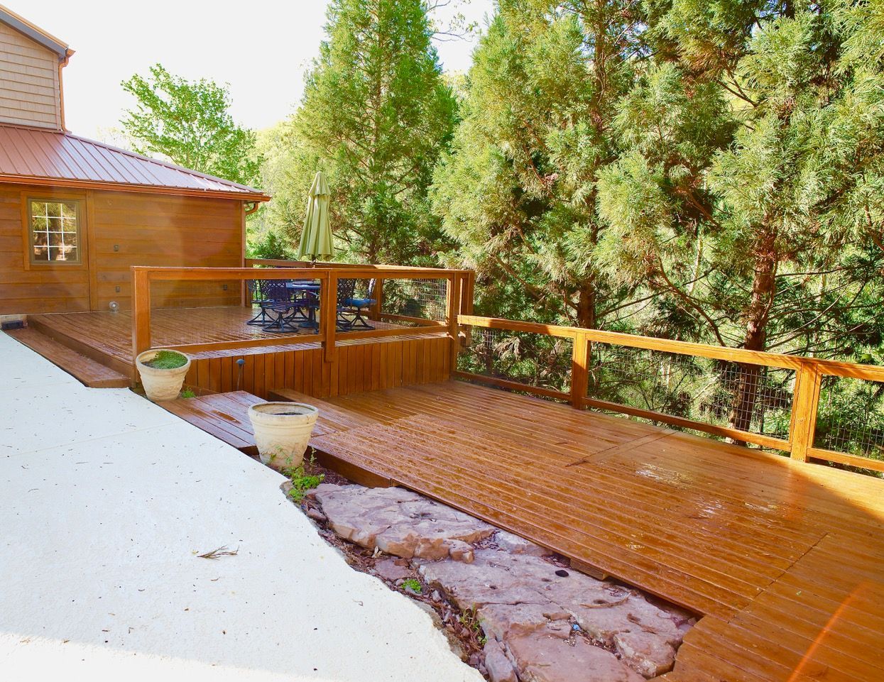 A wooden deck with trees in the background and a house in the background