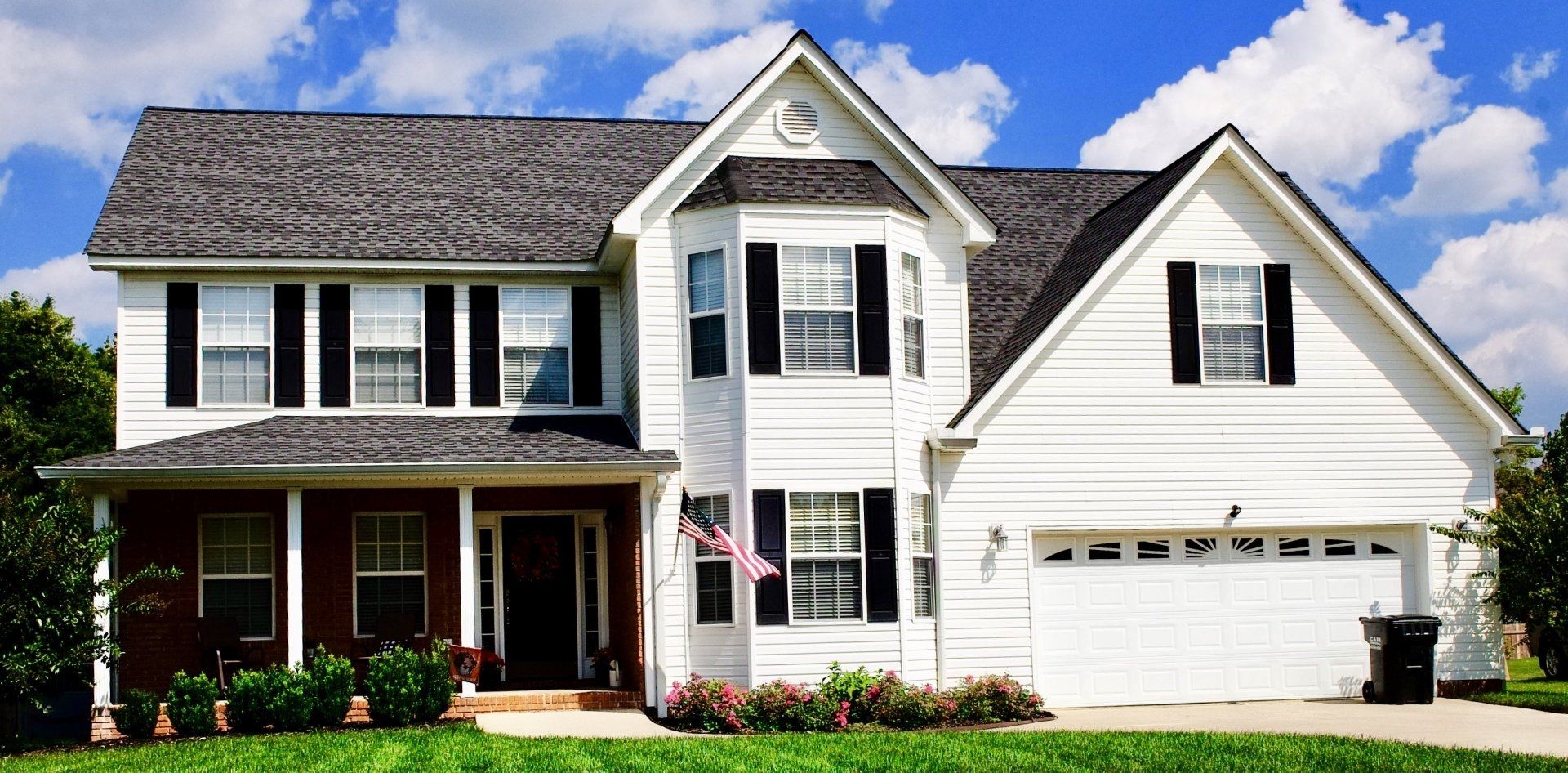 A large white house with black shutters on the windows