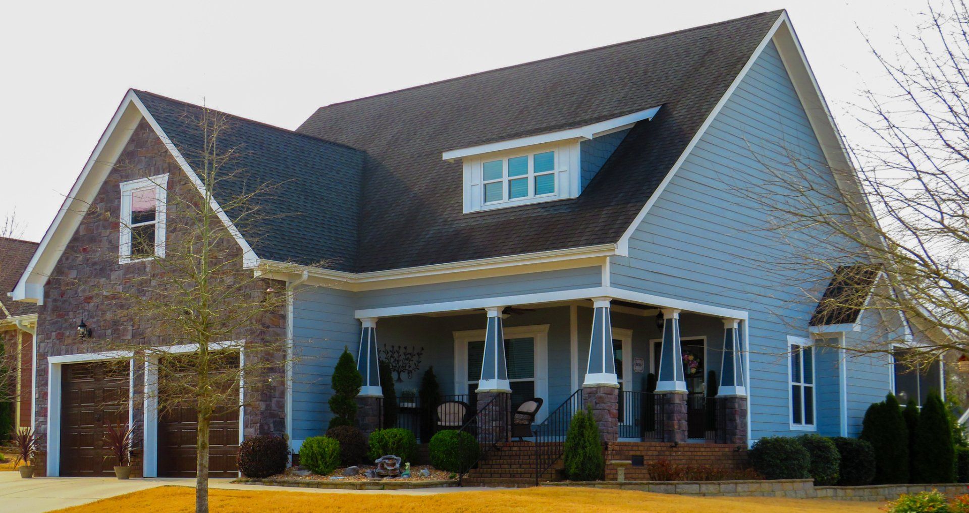 A large blue house with a black roof