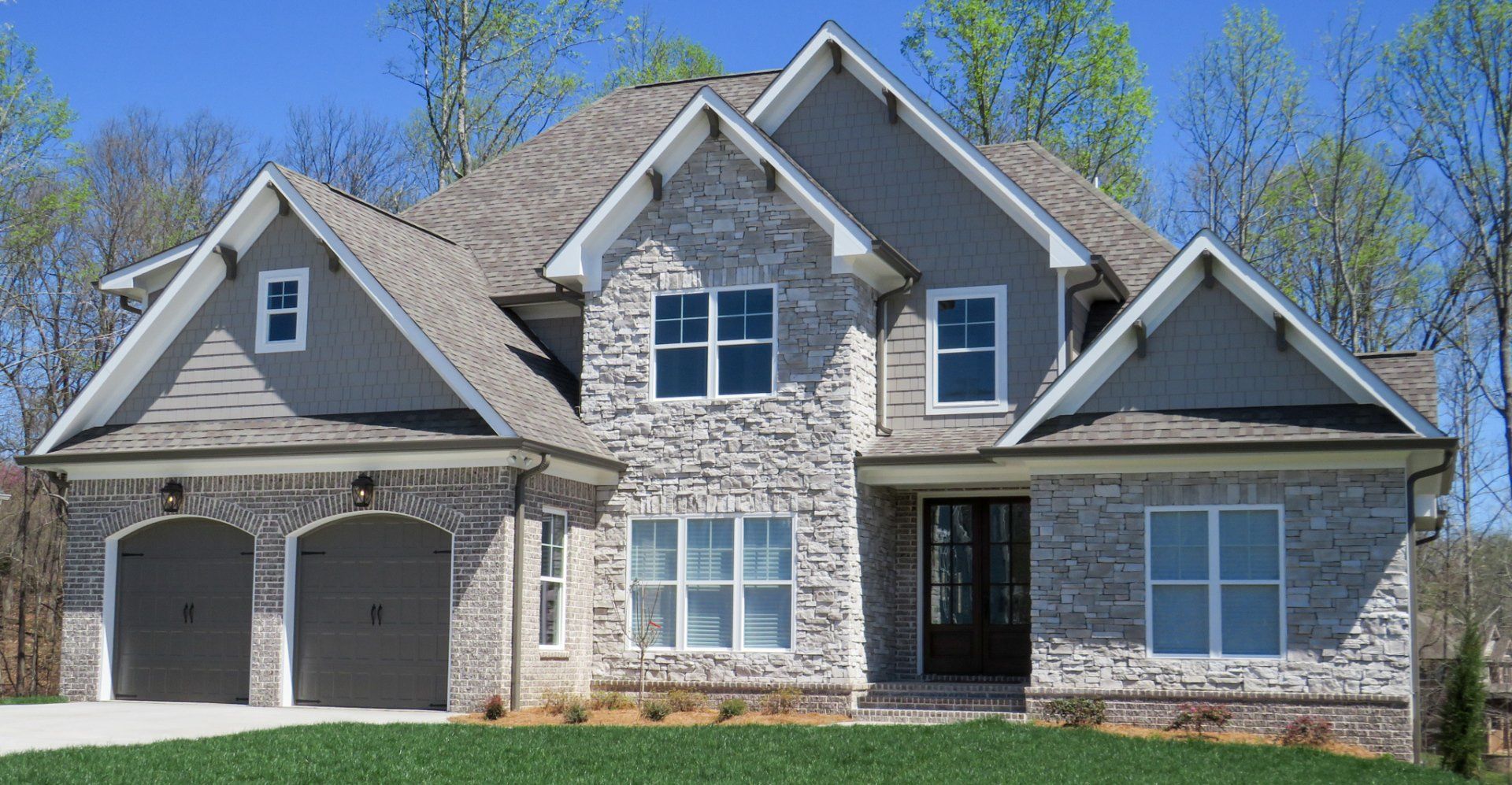 A large brick house with a gray roof and white trim