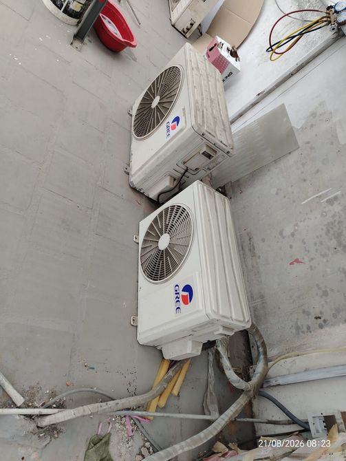 Dos unidades exteriores de aire acondicionado montadas en la pared con cableado visible en un cuarto de servicio.