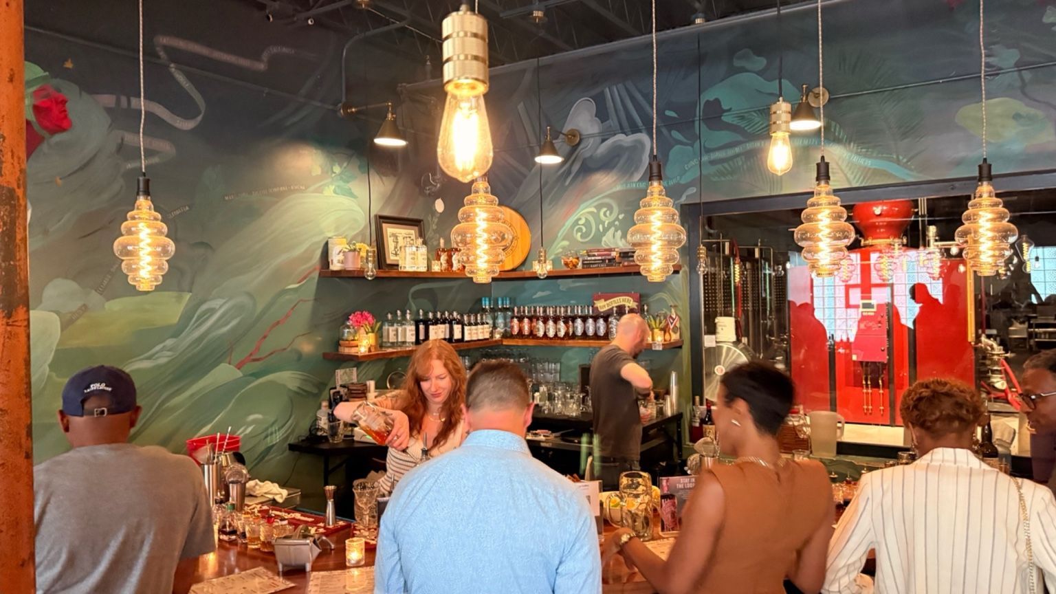 Guests enjoying a gathering beneath pendant lights