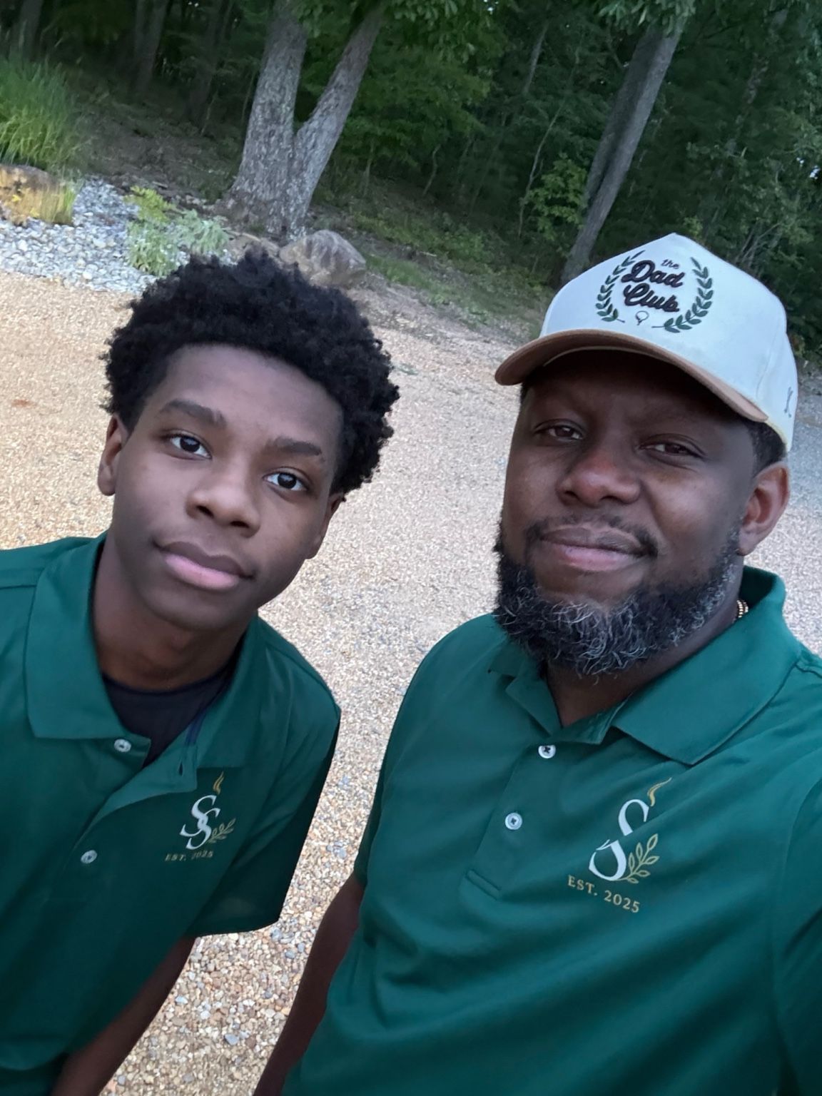 Two team members in green shirts outdoors
