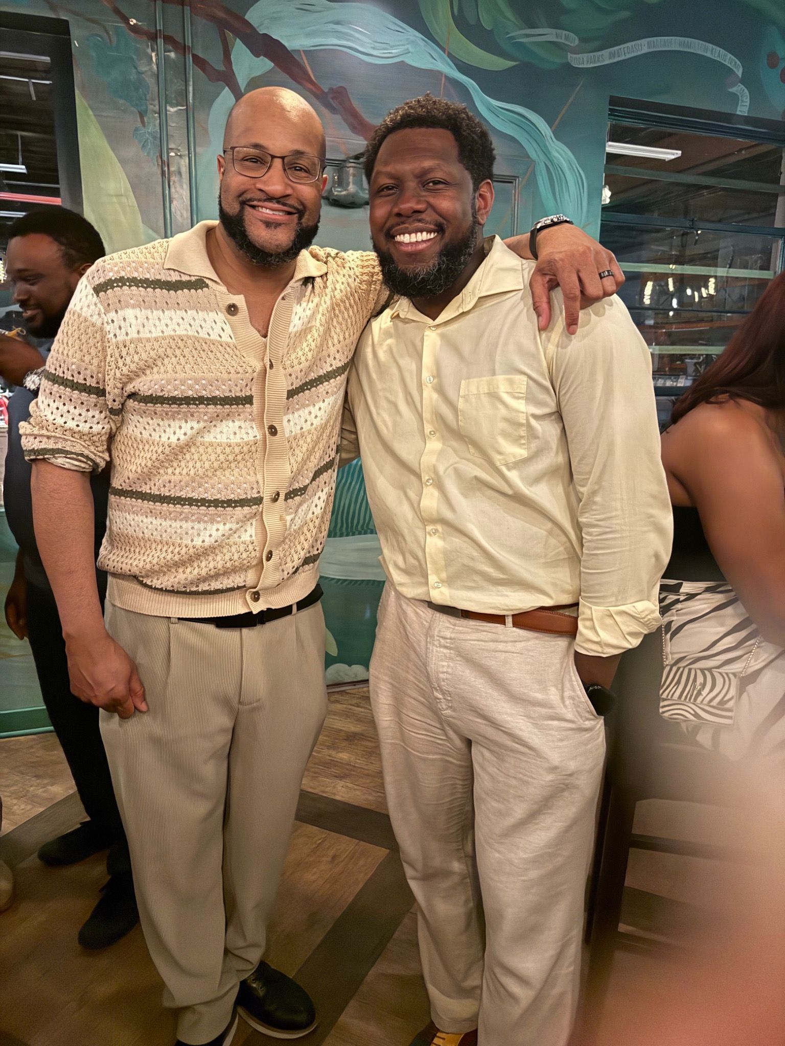 Two guests smiling together at an indoor gathering