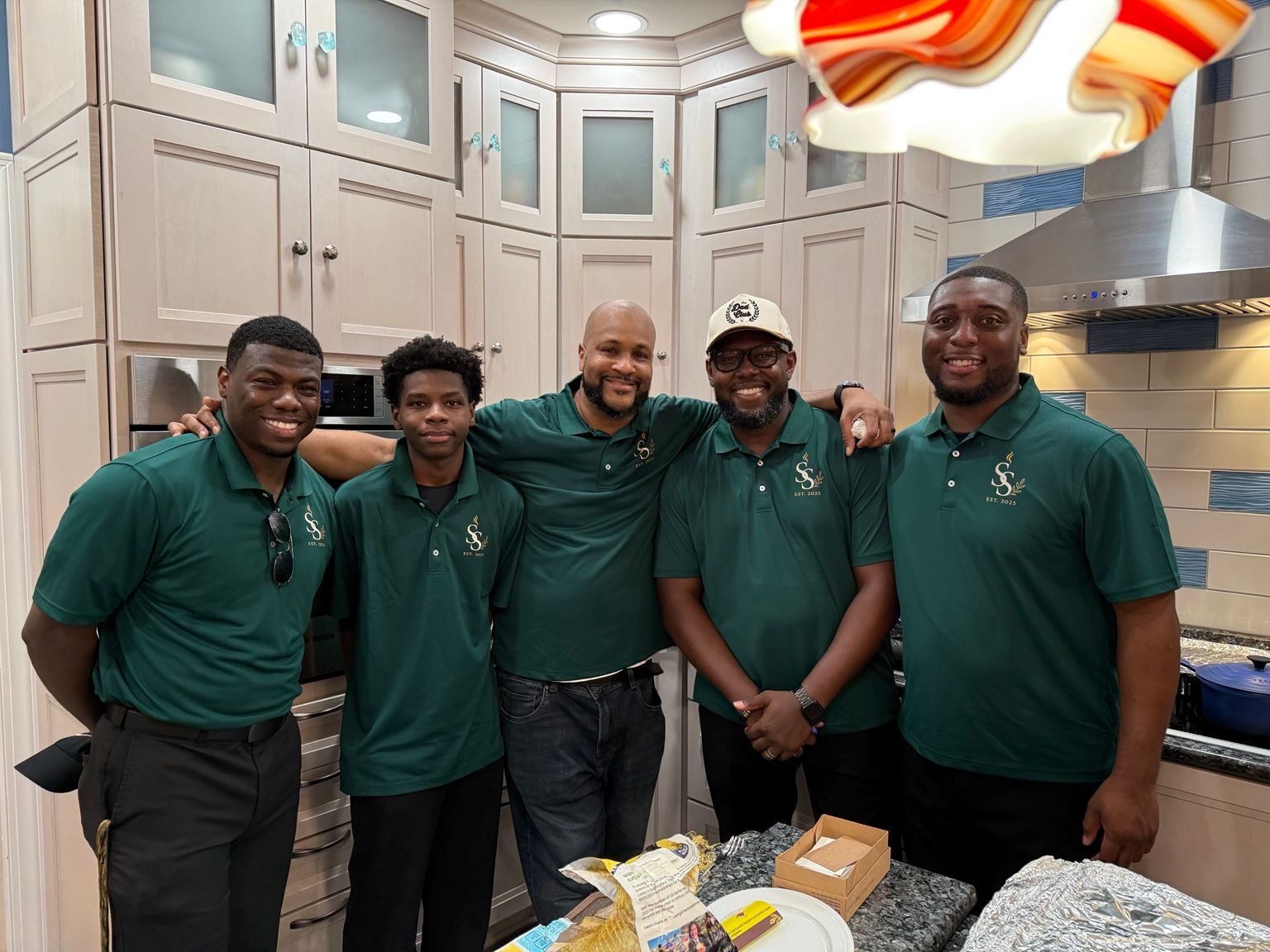 Five team members gathered in a kitchen