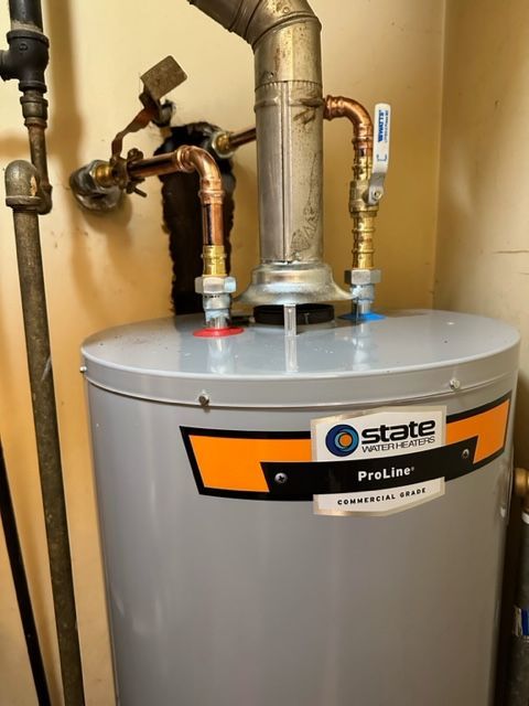 State ProLine water heater with connected copper pipes in a utility closet.