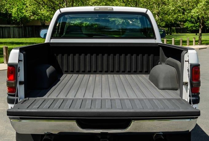 White pickup truck bed with open tailgate, gray bed liner, black trim.