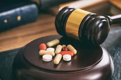 Pill bottles and capsules on a judge’s gavel, symbolizing drug-related legal issues