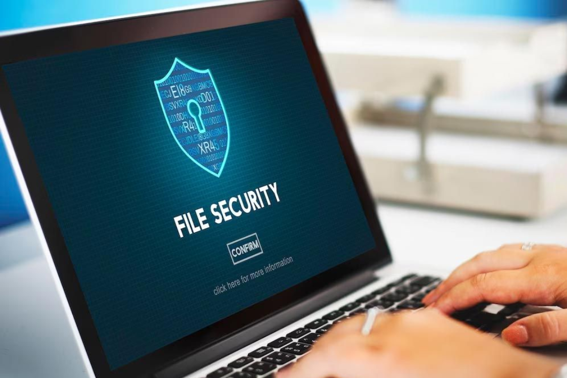 Laptop screen showing “File Security” with a shield icon and hands typing on the keyboard