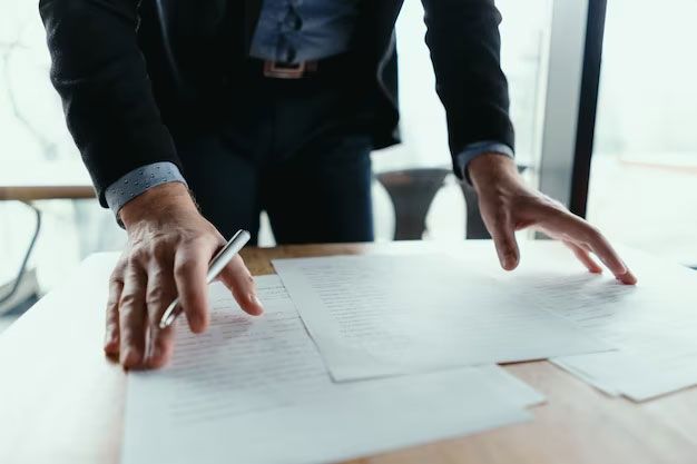 Hands arranging papers on a desk in an office setting
