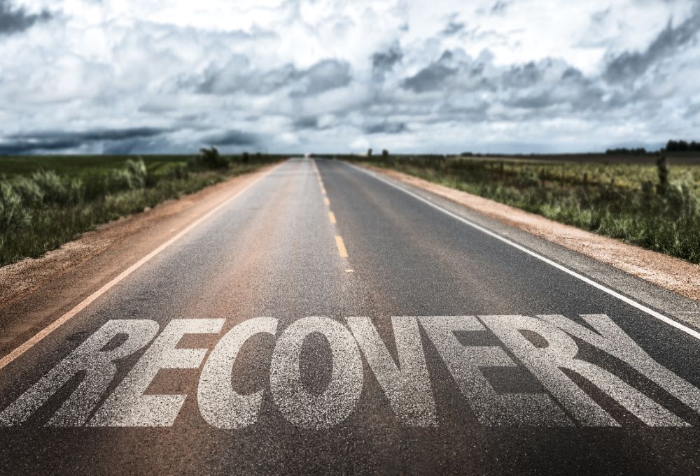 A long road that has the word 'recovery' on it