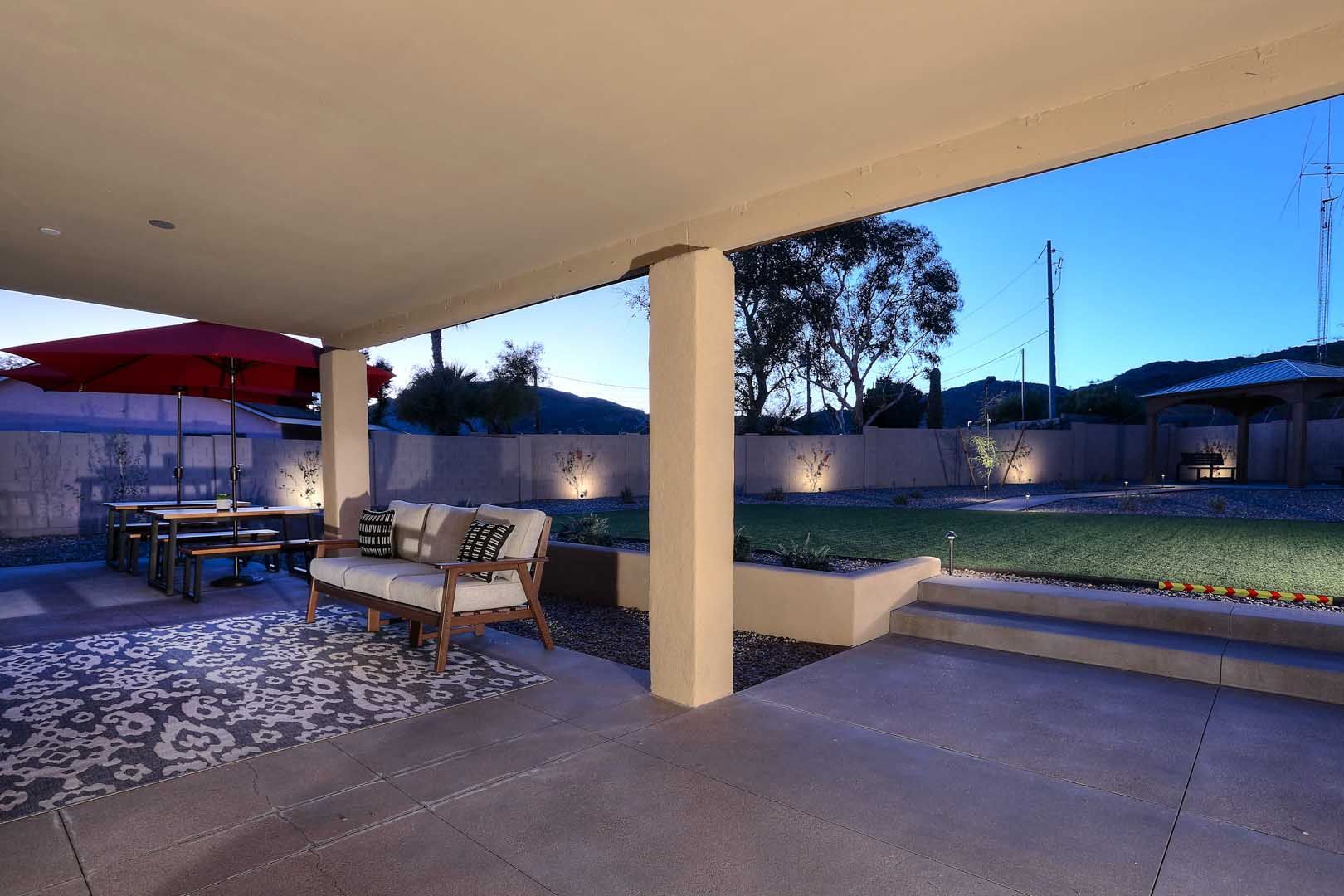 A patio with a couch and umbrellas at night