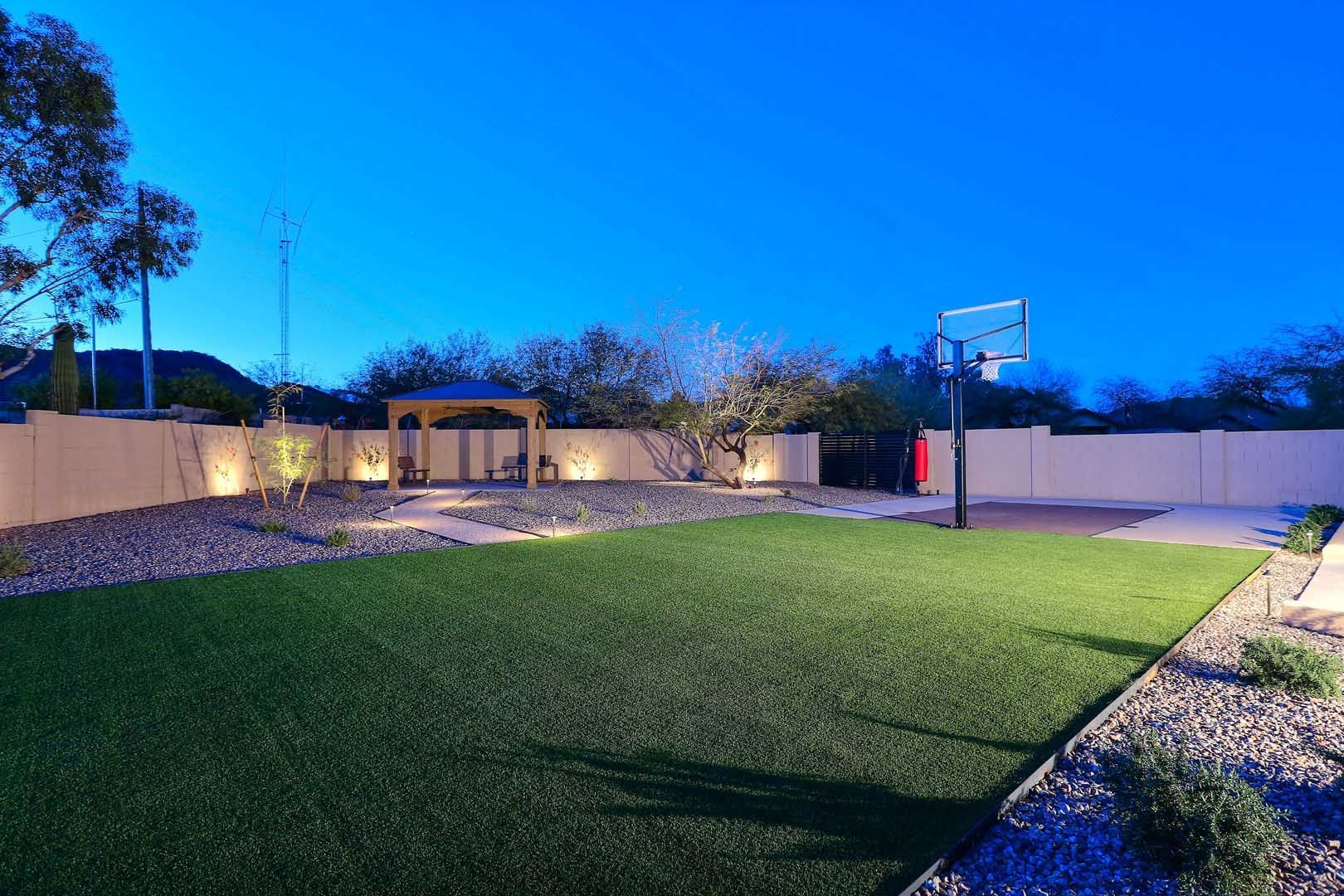 A backyard with a basketball hoop in the middle of it