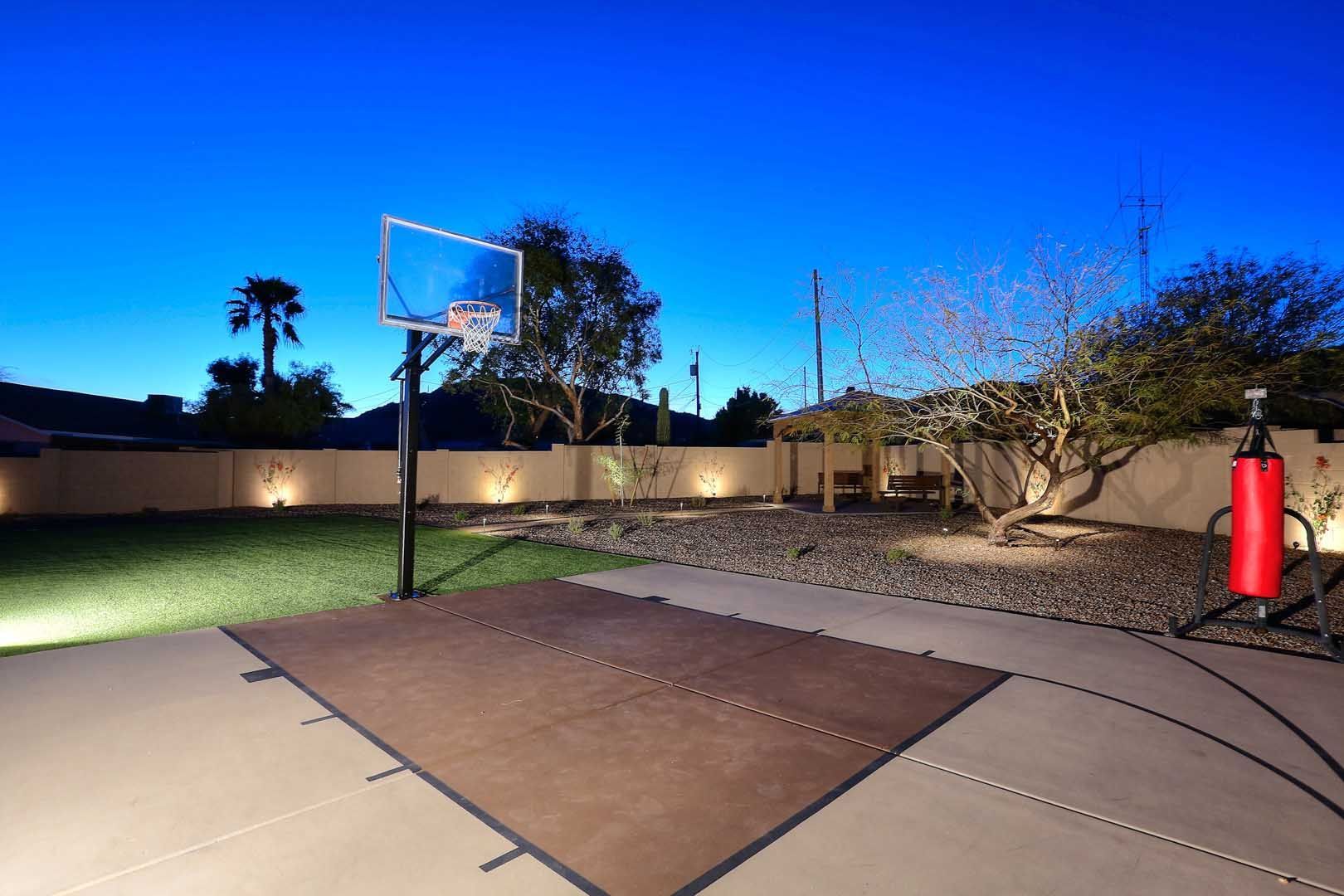 A basketball hoop in a backyard at night