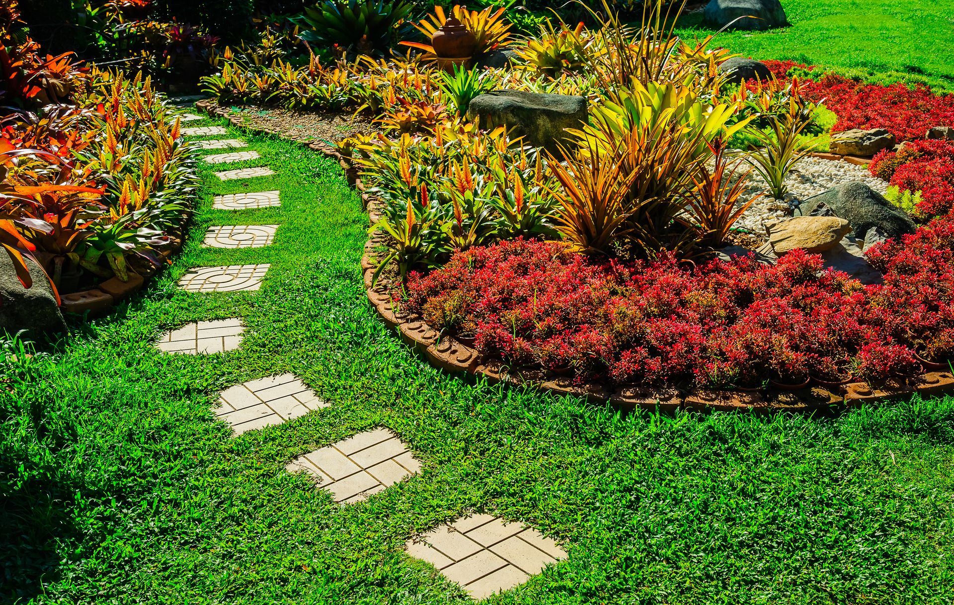 Curved stone path through vibrant landscaped garden beds.