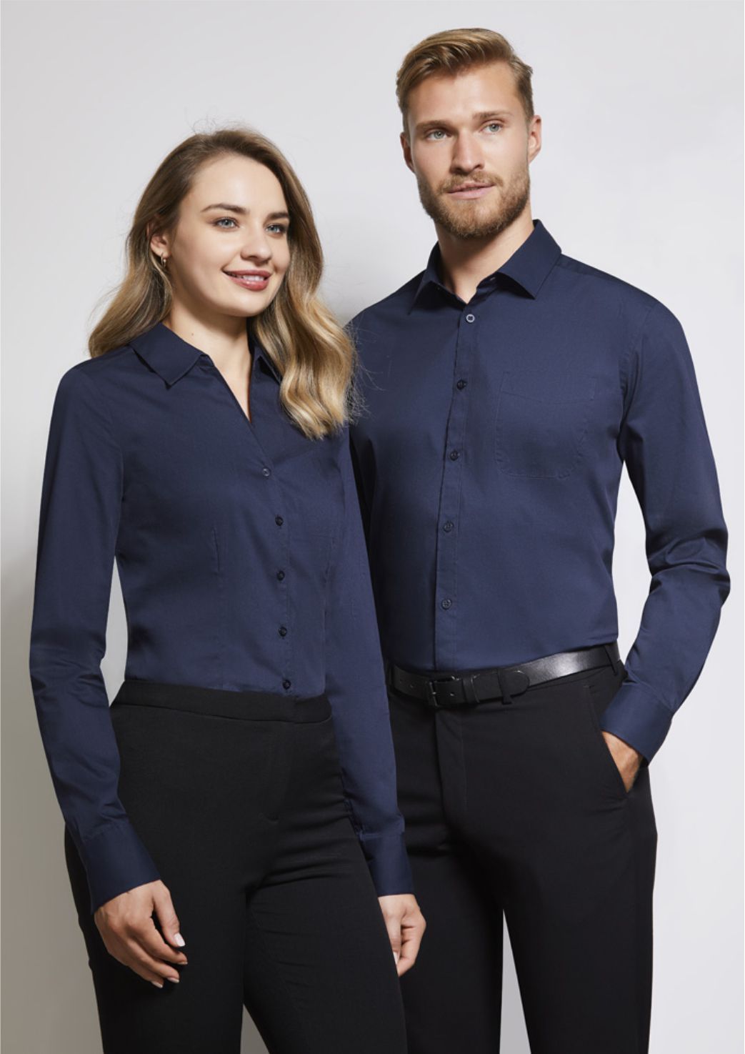 A Man and a Woman Wearing Blue Corporate Shirts and Black Pants — Corporate Workwear in Townsville