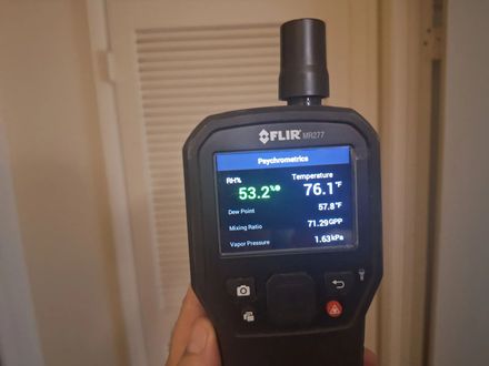 Handheld FLIR moisture meter screen showing air temperature of 76.1°F and relative humidity of 53.2%.