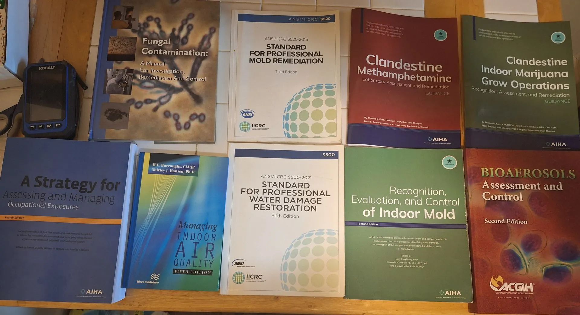 A collection of eight technical manuals and guidebooks from the EPA, arranged in two rows on a wooden surface.