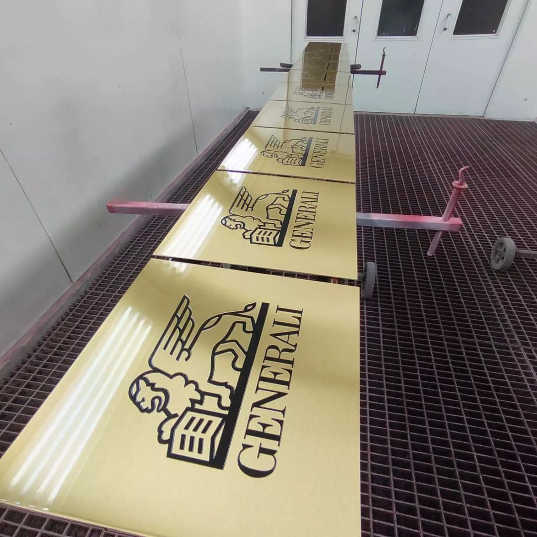 Eine goldene Briefmarke liegt auf einem Stück Papier auf einem Holztisch.