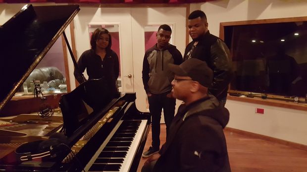 Voices of Glory practicing in a large room with a grand piano.