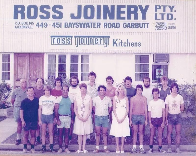 A Group of People Standing in Front of a Building That Says Ross Joinery — Ross Joinery Kitchens In Garbutt, QLD