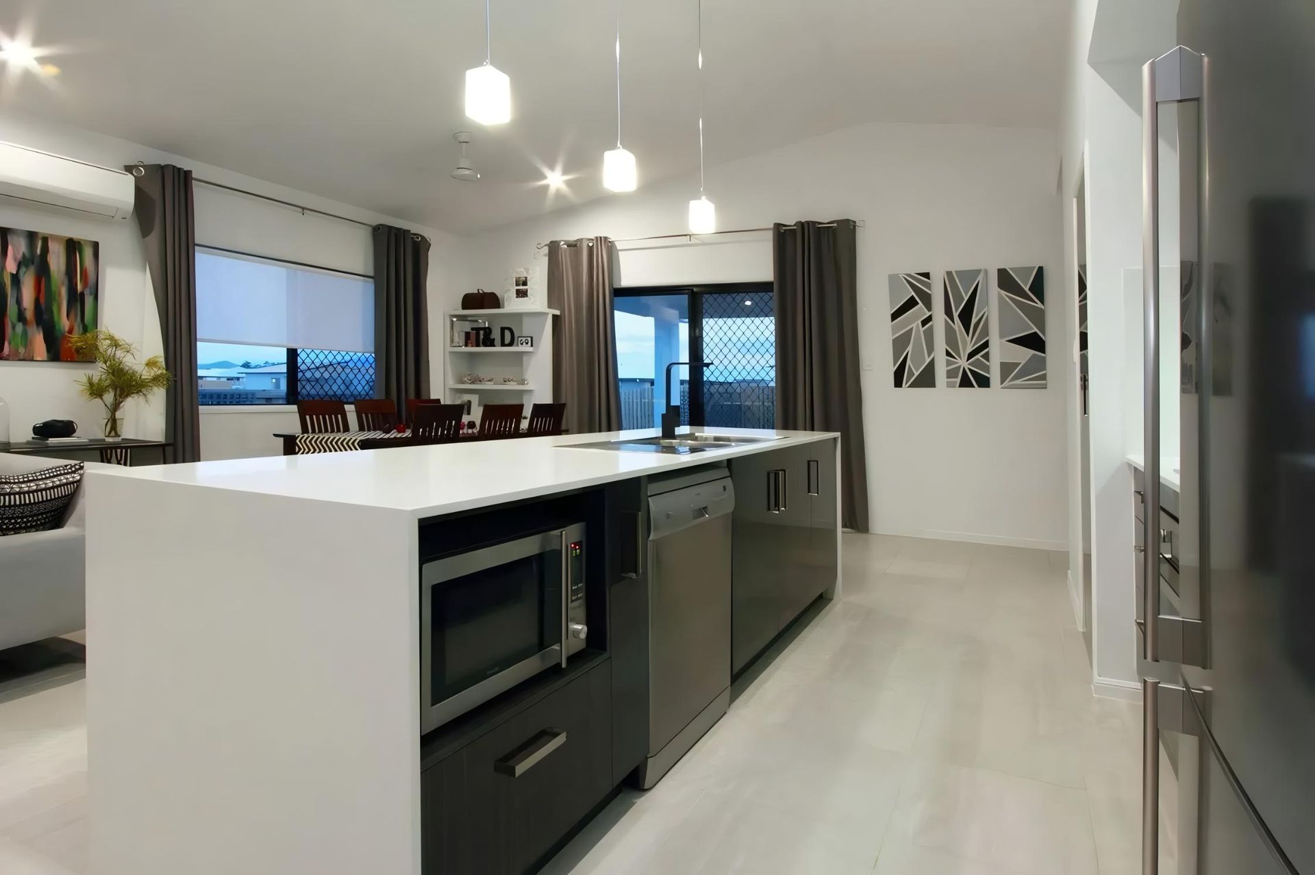 A Kitchen With a Large Island and Stainless Steel Appliances — Ross Joinery Kitchens In Garbutt, QLD