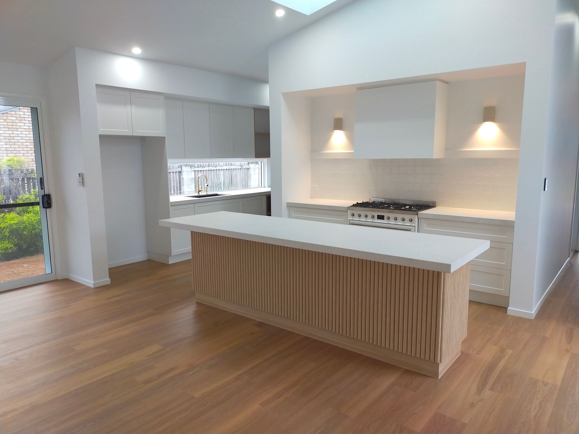 A Kitchen With a Fridge, Cabinets, Drawers and a Table With Fruit on It — Ross Joinery Kitchens In Garbutt, QLD