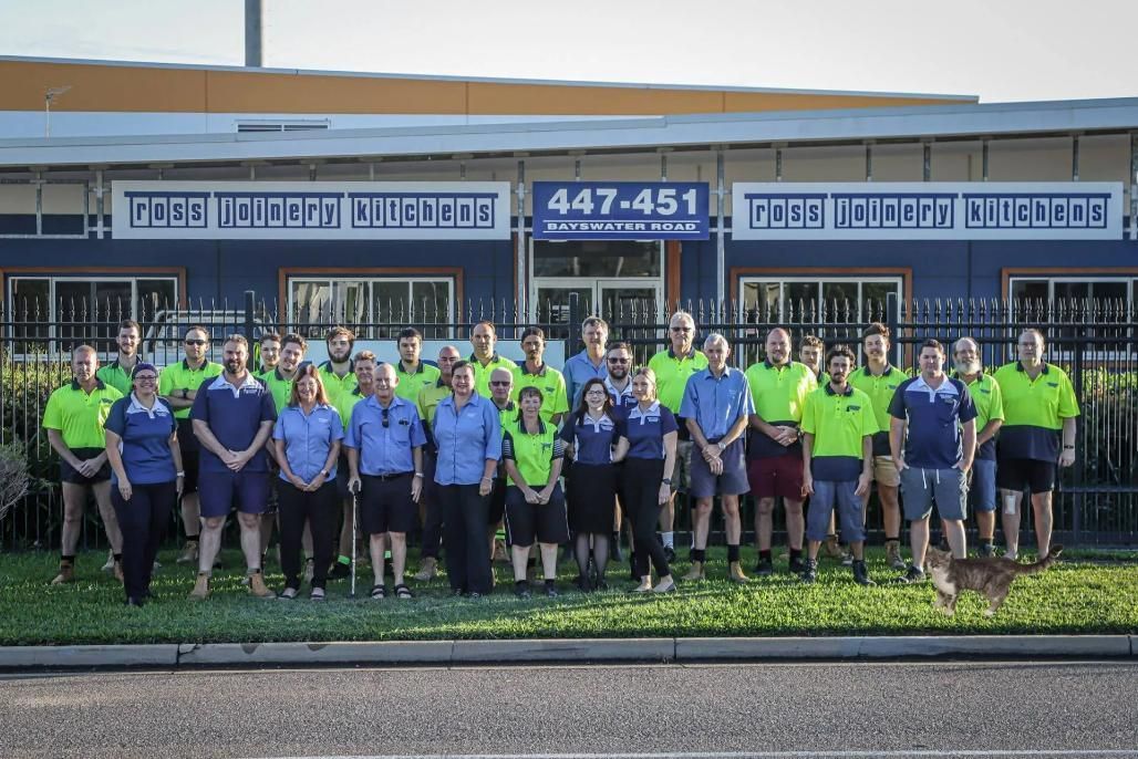 A Group of People Are Posing for a Picture in Front of a Ross Joinery Kitchens Building — Ross Joinery Kitchens In Garbutt, QLD