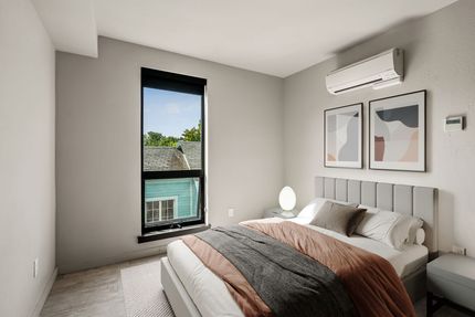 Photo of a bedroom with a unique window that is very tall