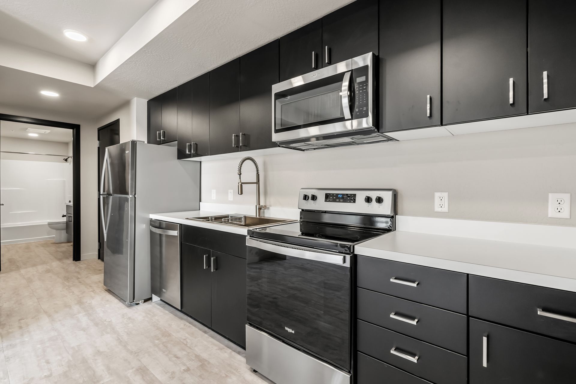 Photo of a kitchen with a bathroom in the background