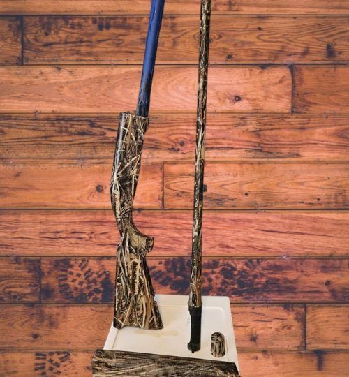 Two long-handled brooms leaning against a white base on a wooden floor.