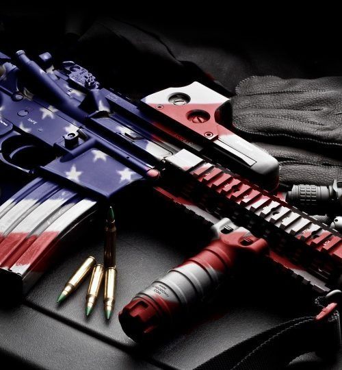 American-flag-themed rifle with ammunition on a dark background, plus a red-and-black flashlight/knife gear