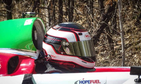 A person wearing a helmet is sitting in a race car.